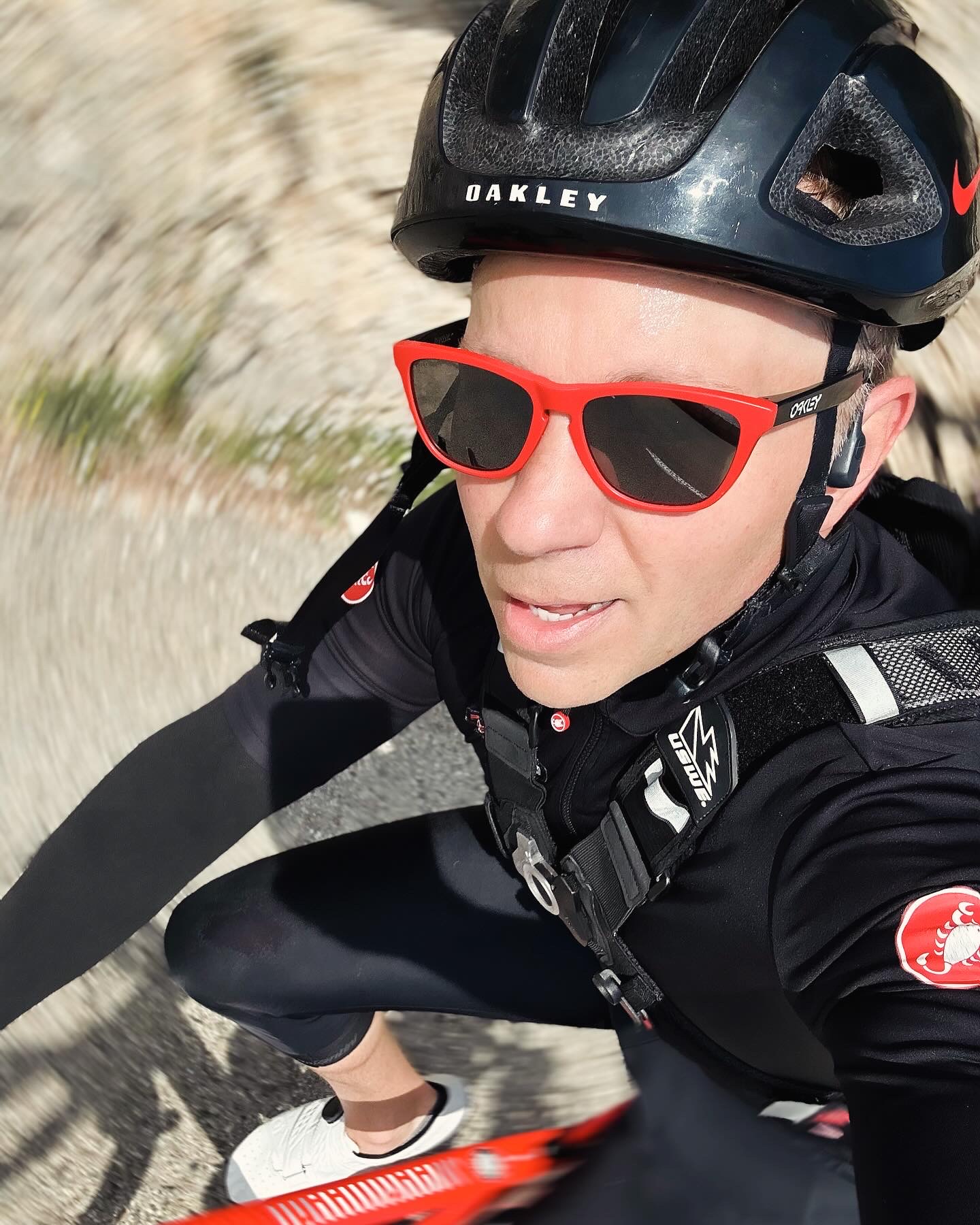 Justin riding a road bike on a sunlit mountain climb